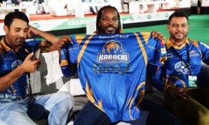 Pakistan Super League (PSL) team Karachi Kings player Chris Gayle (C) holds team shirt during second edition of PSL draft in Dubai on October 19, 2016. PSL which will be held in United Arab Emirates in February-March 2017.